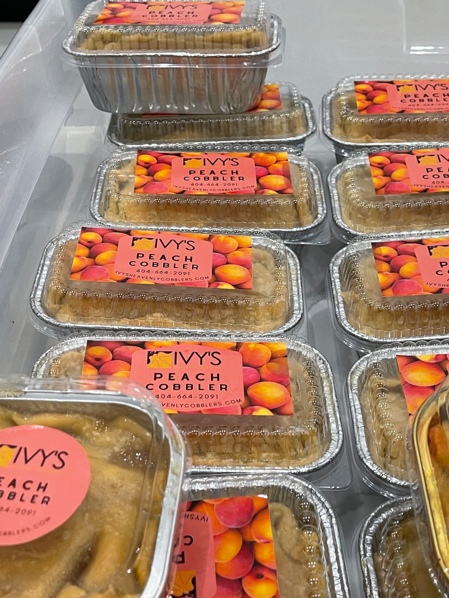 Labeled Ivy's peach cobbler loaf pans lined up in the case