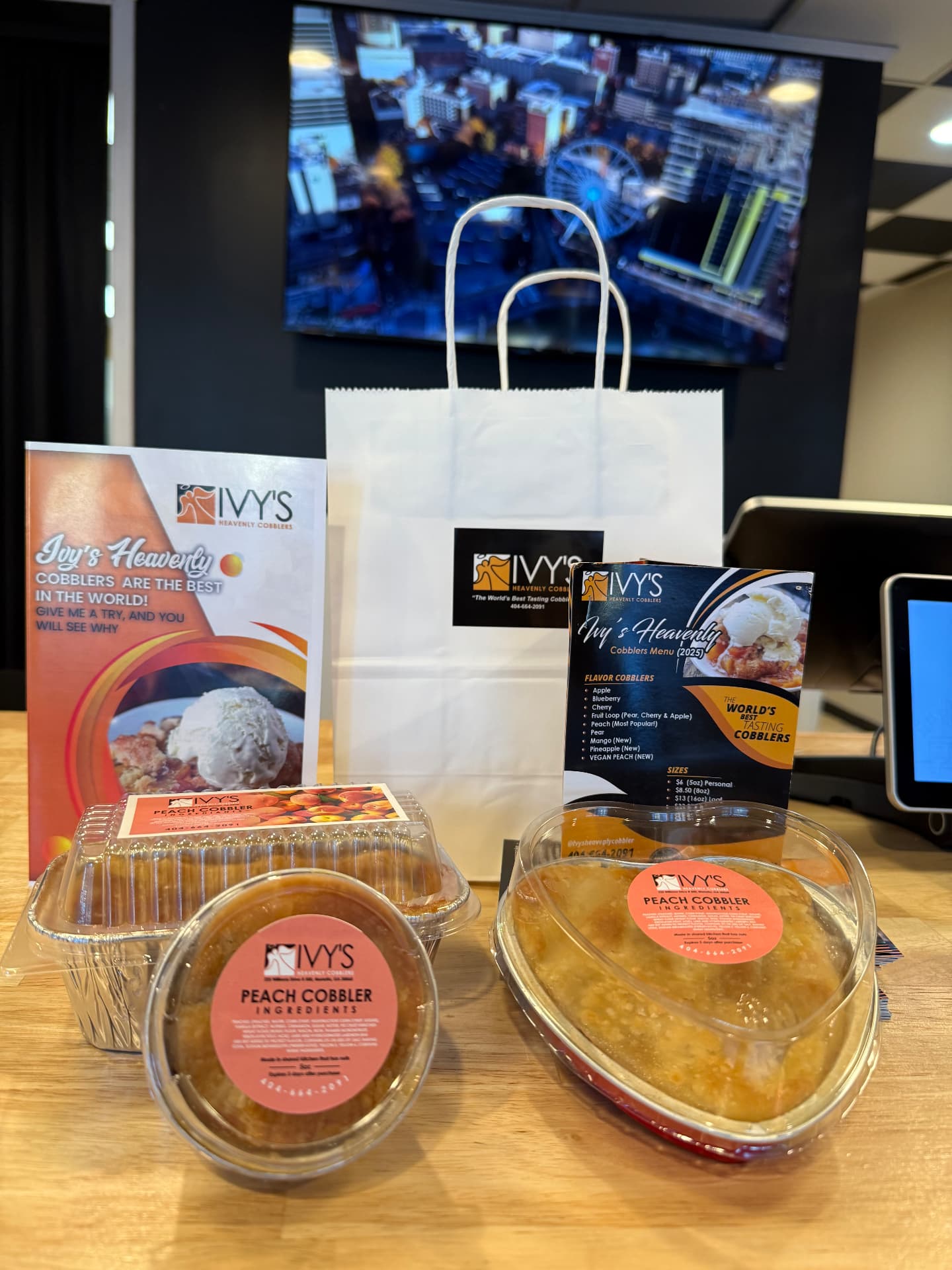 Ivy's takeout bag, menu card and packaged peach cobblers on the counter